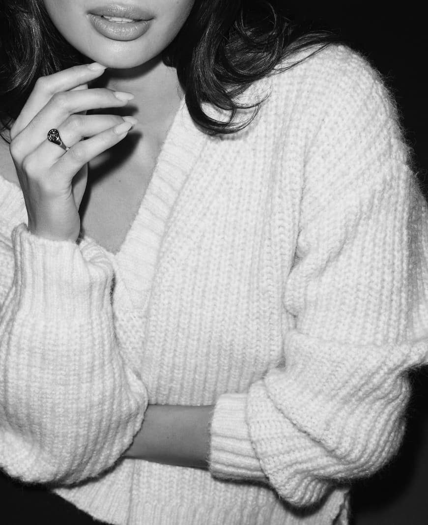 A model wears a white boxy v-neck sweater